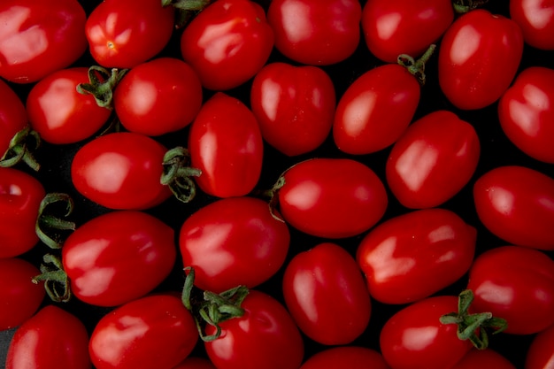 Vista superior de tomates cereja maduros em fundo preto