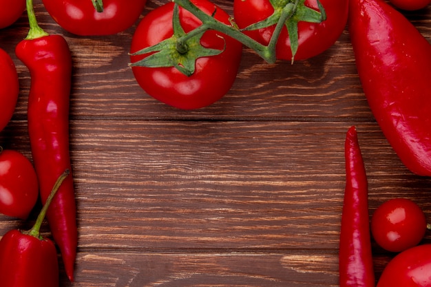 Vista superior de tomates maduros de legumes frescos com pimenta vermelha em madeira rústica, com espaço de cópia