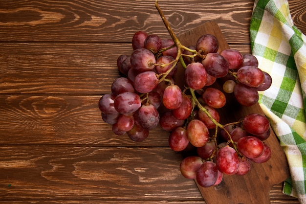 Vista superior de um cacho de uvas frescas na mesa rústica de madeira