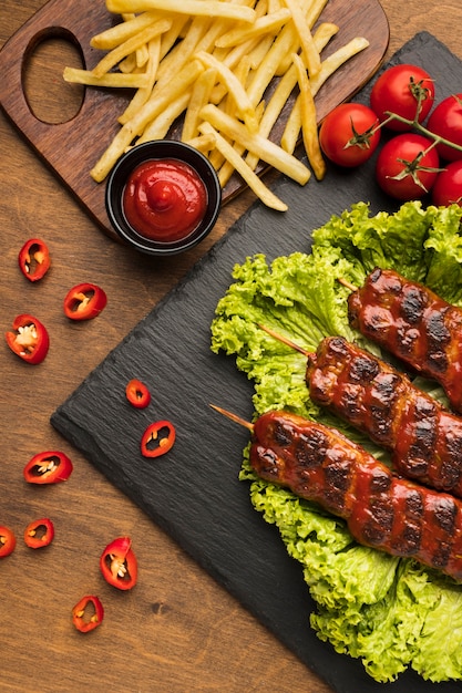 Foto grátis vista superior de um delicioso kebab em ardósia com tomates e batatas fritas