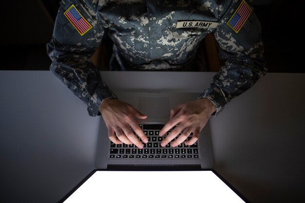 Vista superior de um soldado americano em uniforme militar digitando no computador