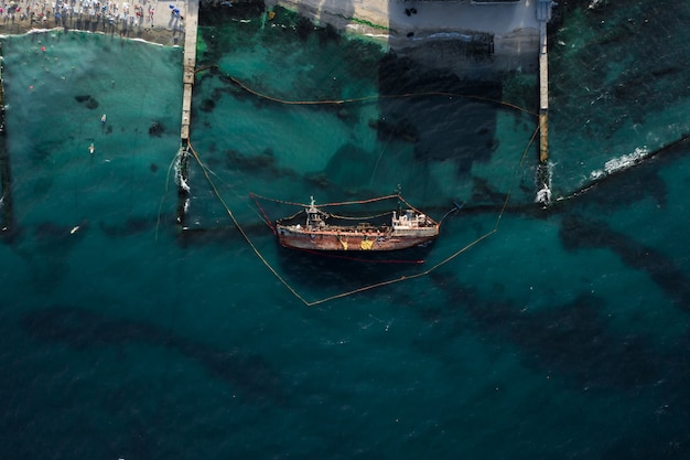 Vista superior de um velho petroleiro que encalhou e capotou