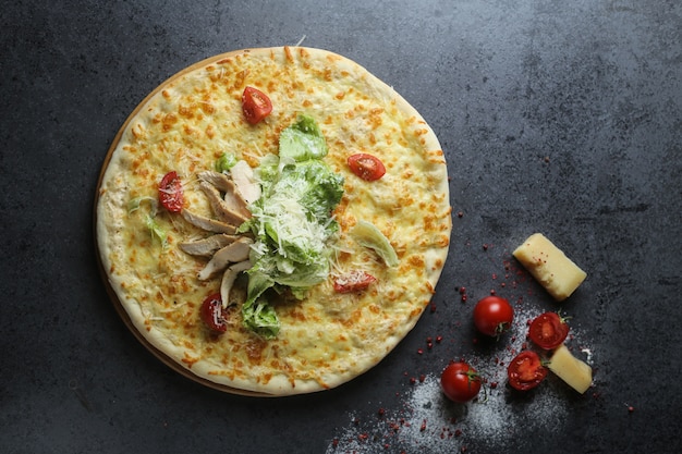 Vista superior de uma deliciosa pizza com tomate e queijo em uma mesa