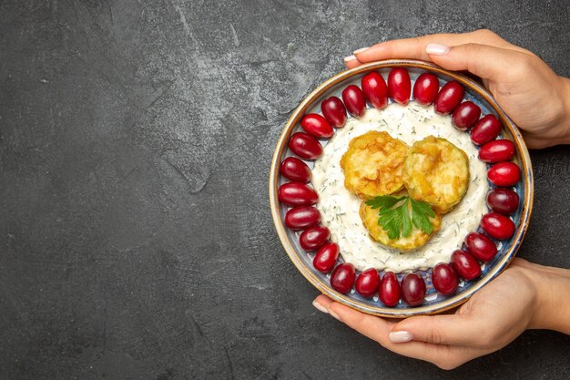 Vista superior de uma deliciosa refeição de abóbora com dogwoods vermelhos frescos na superfície cinza