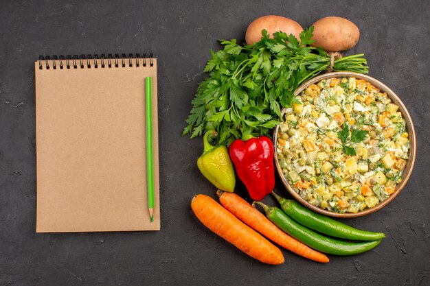 Foto grátis vista superior de uma deliciosa salada com legumes frescos em superfície escura