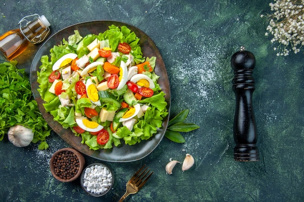 Vista superior de uma deliciosa salada com muitos ingredientes frescos, especiarias, alho, caído, garrafa, flor