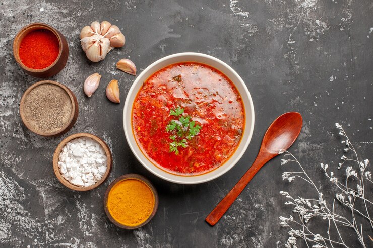 Foto grátis vista superior de uma deliciosa sopa de beterraba com temperos na superfície escura