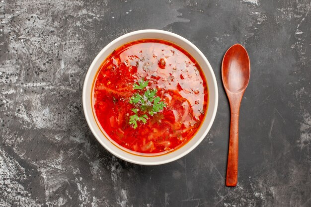 Vista superior de uma deliciosa sopa de legumes vermelha de borsch em uma superfície escura