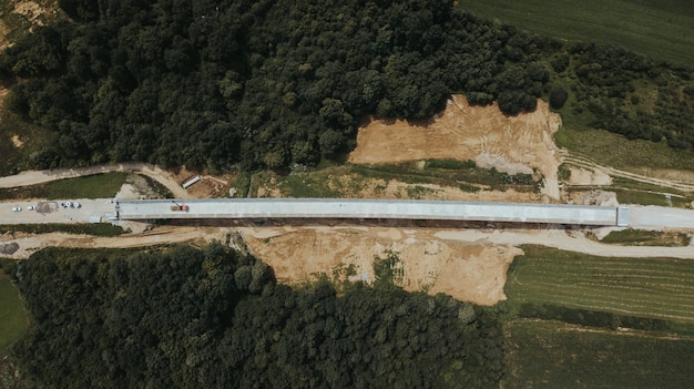 Vista superior de uma estrada em construção no distrito de Brcko, cercada por campos, na Bósnia e Herzegovina