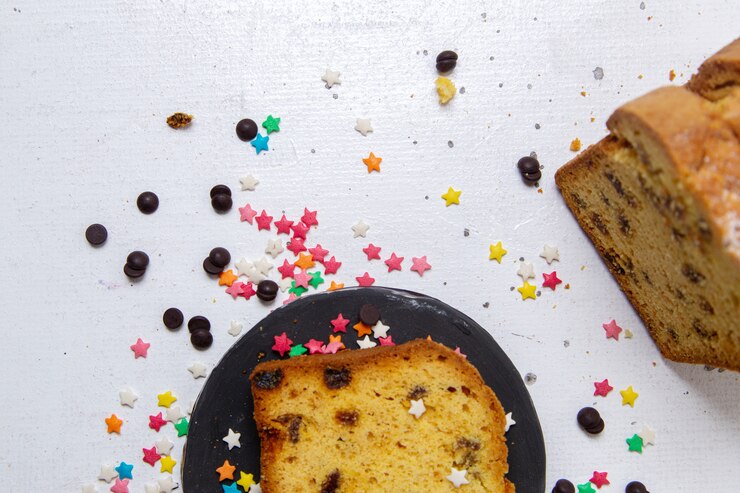 Foto grátis vista superior de uma fatia de bolo dentro de um prato escuro com doces coloridos na mesa de luz bolo doce biscoito assado