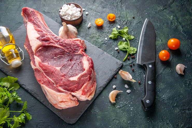Foto grátis vista superior de uma grande fatia de carne crua com verduras na superfície escura