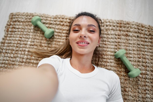 Vista superior de uma jovem em forma se exercitando em uma esteira em casa