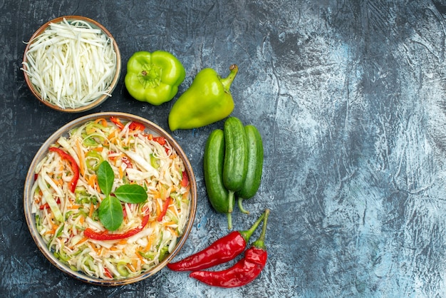 Vista superior de uma saborosa salada de vegetais em superfície escura