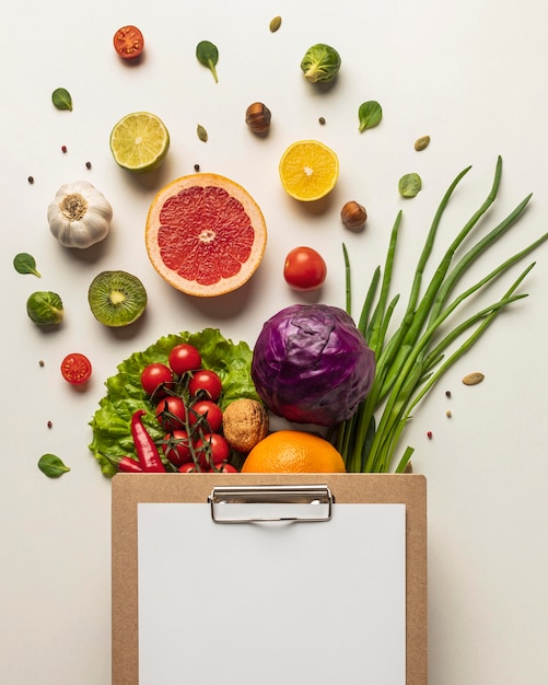 Vista superior de uma variedade de vegetais com prancheta