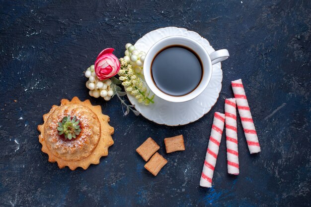 Vista superior de uma xícara de café com balas rosa e delicioso bolo em azul, bolo doce biscoito café bebida