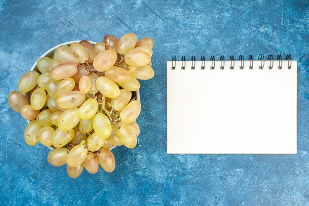 Foto grátis vista superior de uvas frescas dentro do prato na mesa azul