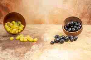 Foto grátis vista superior de uvas frescas pretas e amarelas caídas de pequenos vasos