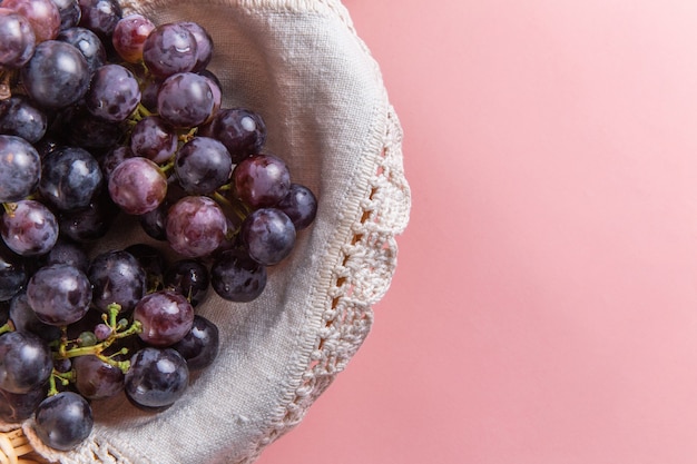 Vista superior de uvas verdes frescas dentro da cesta na superfície rosa