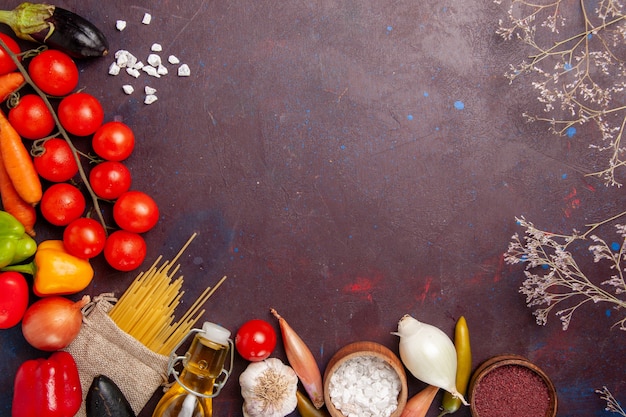 Vista superior de vegetais frescos com massa italiana crua no espaço escuro