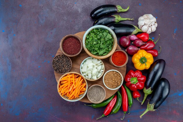 Vista superior de vegetais frescos com temperos e verduras na mesa escura