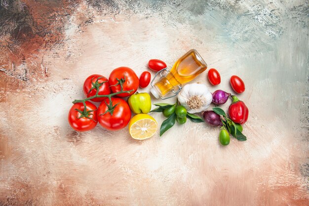 Vista superior de vegetais frutas cítricas cebola alho tomate limão com pedicelos óleo de pimenta