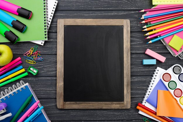 Vista superior de volta aos artigos de papelaria da escola com lápis coloridos e quadro-negro