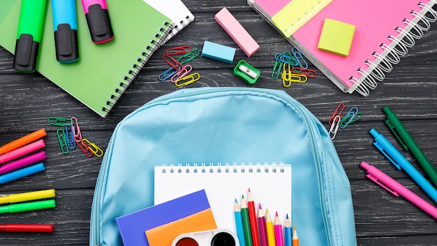 Vista superior de volta aos artigos de papelaria da escola com mochila