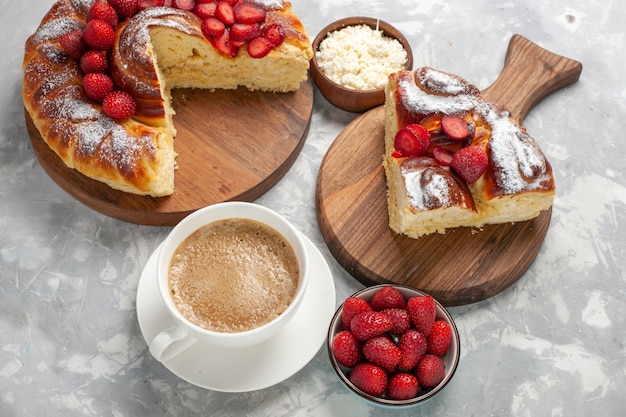 Vista superior deliciosa fatia de torta com morangos vermelhos frescos e café na superfície branca clara torta bolo biscoito chá doce açúcar