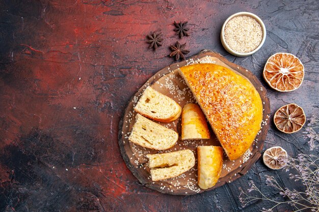 Vista superior deliciosa massa doce fatiada em pedaços na superfície escura