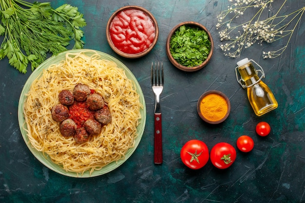 Vista superior deliciosa massa italiana com almôndegas e molho de tomate na mesa azul