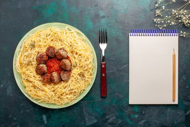 Vista superior deliciosa massa italiana com almôndegas e molho de tomate na superfície azul-escura massa massa comida refeição prato jantar
