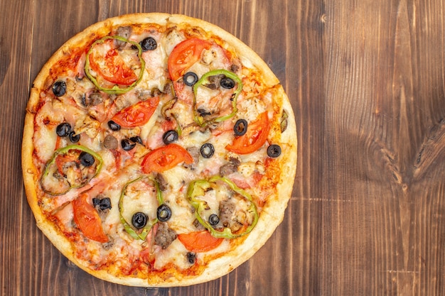 Vista superior deliciosa pizza de queijo em superfície de madeira marrom