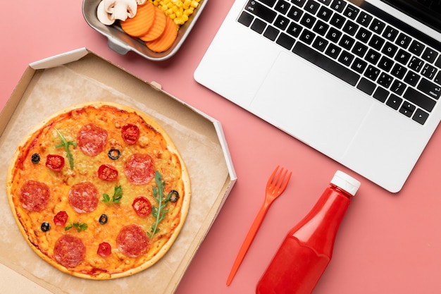 Vista superior deliciosa pizza e laptop