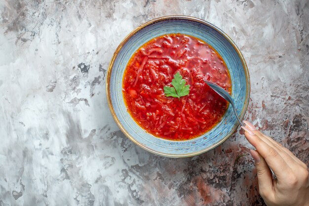 Vista superior deliciosa sopa de beterraba ucraniana borsch dentro do prato sobre fundo branco claro