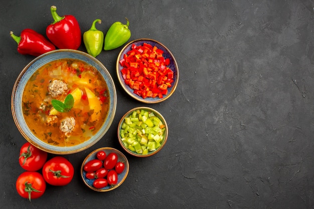 Foto grátis vista superior deliciosa sopa de carne com legumes frescos na mesa escura prato foto refeição comida