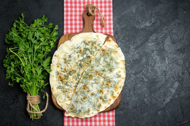 Vista superior deliciosas fatias de massa cozida com verduras frescas em um espaço cinza