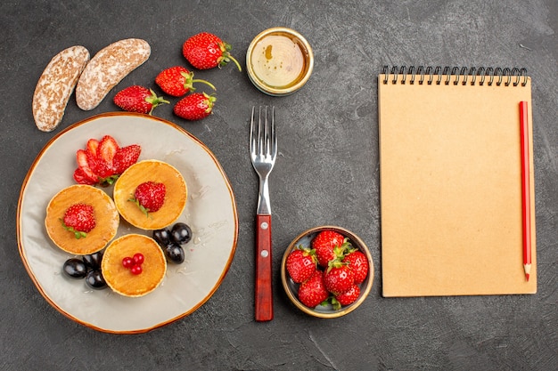 Vista superior deliciosas panquecas com frutas no escuro