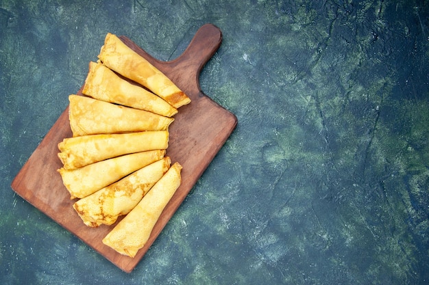 Foto grátis vista superior deliciosas panquecas enroladas em superfície escura