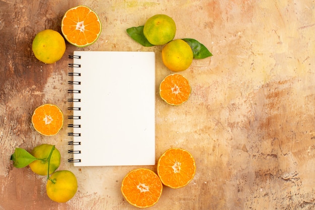 Vista superior deliciosas tangerinas frescas com bloco de notas