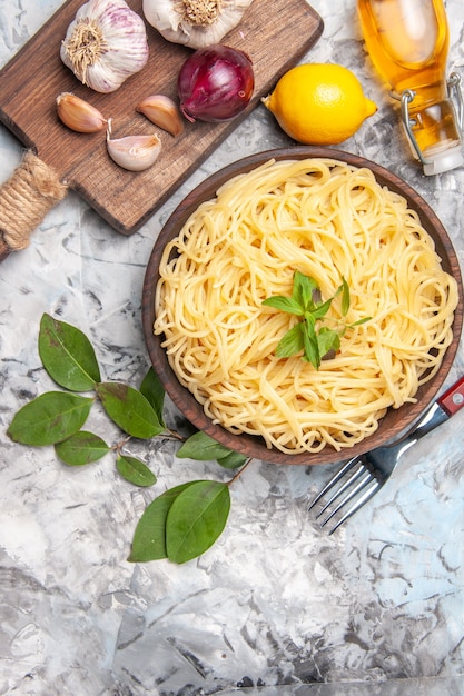Vista superior delicioso espaguete com alho na mesa branca massa de macarrão refeição pimenta
