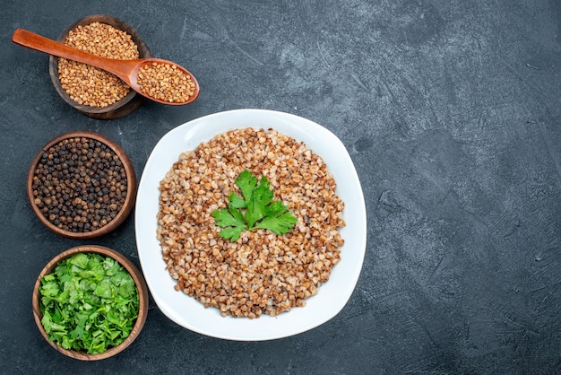 Vista superior delicioso trigo sarraceno cozido com verduras no espaço cinza