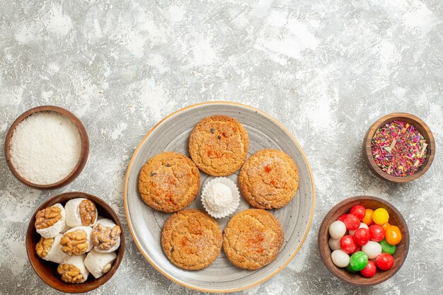 Vista superior deliciosos biscoitos de areia com doces no fundo branco