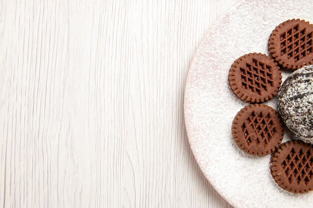 Vista superior deliciosos biscoitos de chocolate com bolinho de cacau em branco