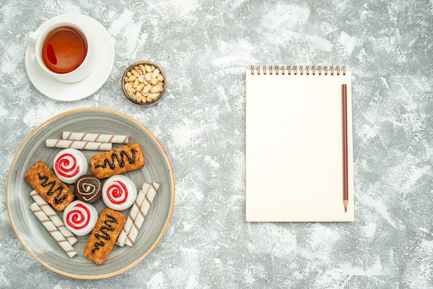 Foto grátis vista superior deliciosos biscoitos doces com bolos e chá no espaço em branco