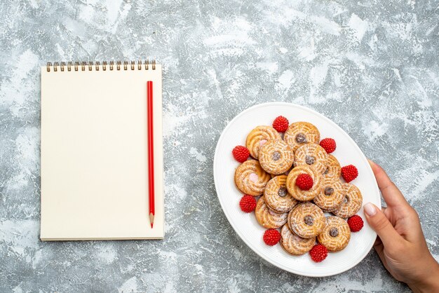 Vista superior deliciosos biscoitos redondos com confit de framboesa em um espaço em branco claro