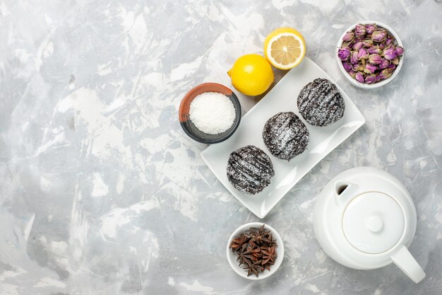 Vista superior deliciosos bolinhos com limão no fundo branco chocolate bolo de cacau biscoito doce açúcar chá