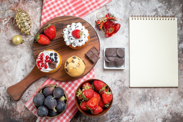 Vista superior deliciosos bolos com frutas frescas em fundo claro