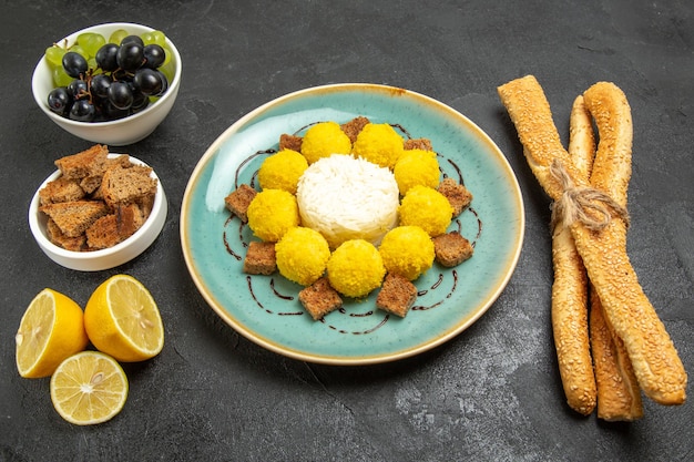 Vista superior deliciosos doces amarelos com bolo de uvas e pão no fundo escuro açúcar frutas doces chá bolo doce