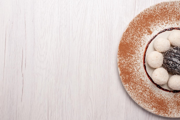 Vista superior deliciosos doces de coco com bolo de chocolate na mesa branca Bolo de açúcar biscoito biscoito doce