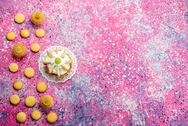 Vista superior distante de um pequeno bolo delicioso com biscoitos de frutas fatiadas, bolo doce açúcar